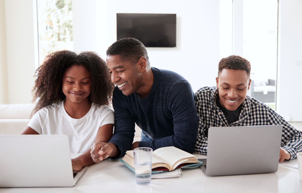 Father and his children doing working with their laptops at home